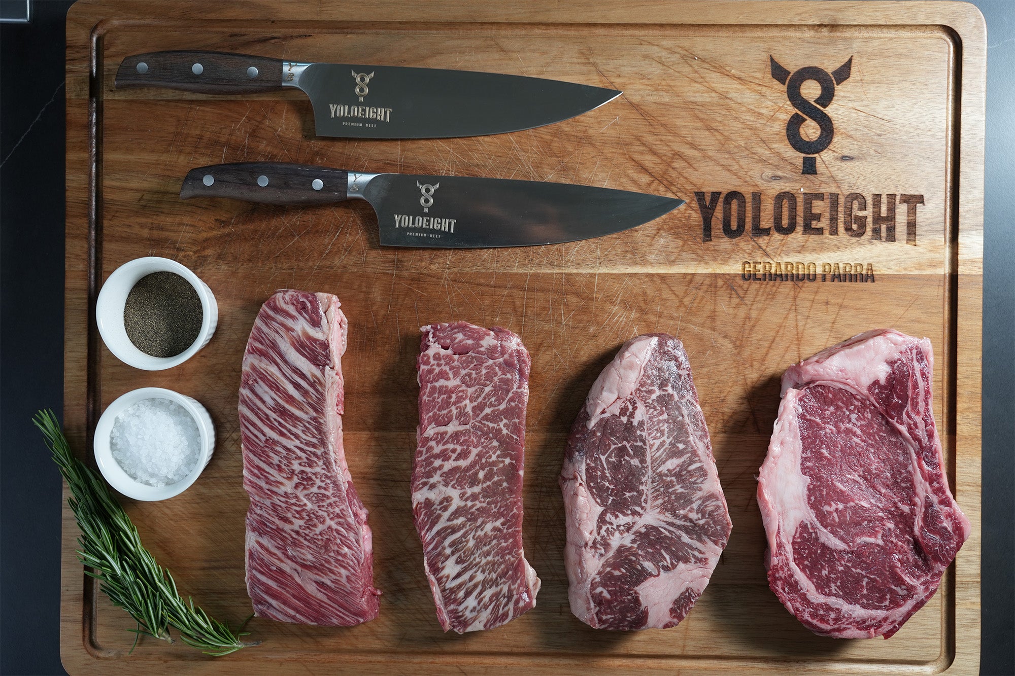 Wooden cutting board with raw steaks, knives, and YOLO Eight branding.