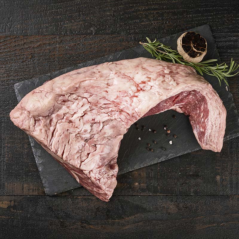 A large tri tip roast from Yolo 8 Meats, so large it overhangs the black stone cutting board it's sitting on.